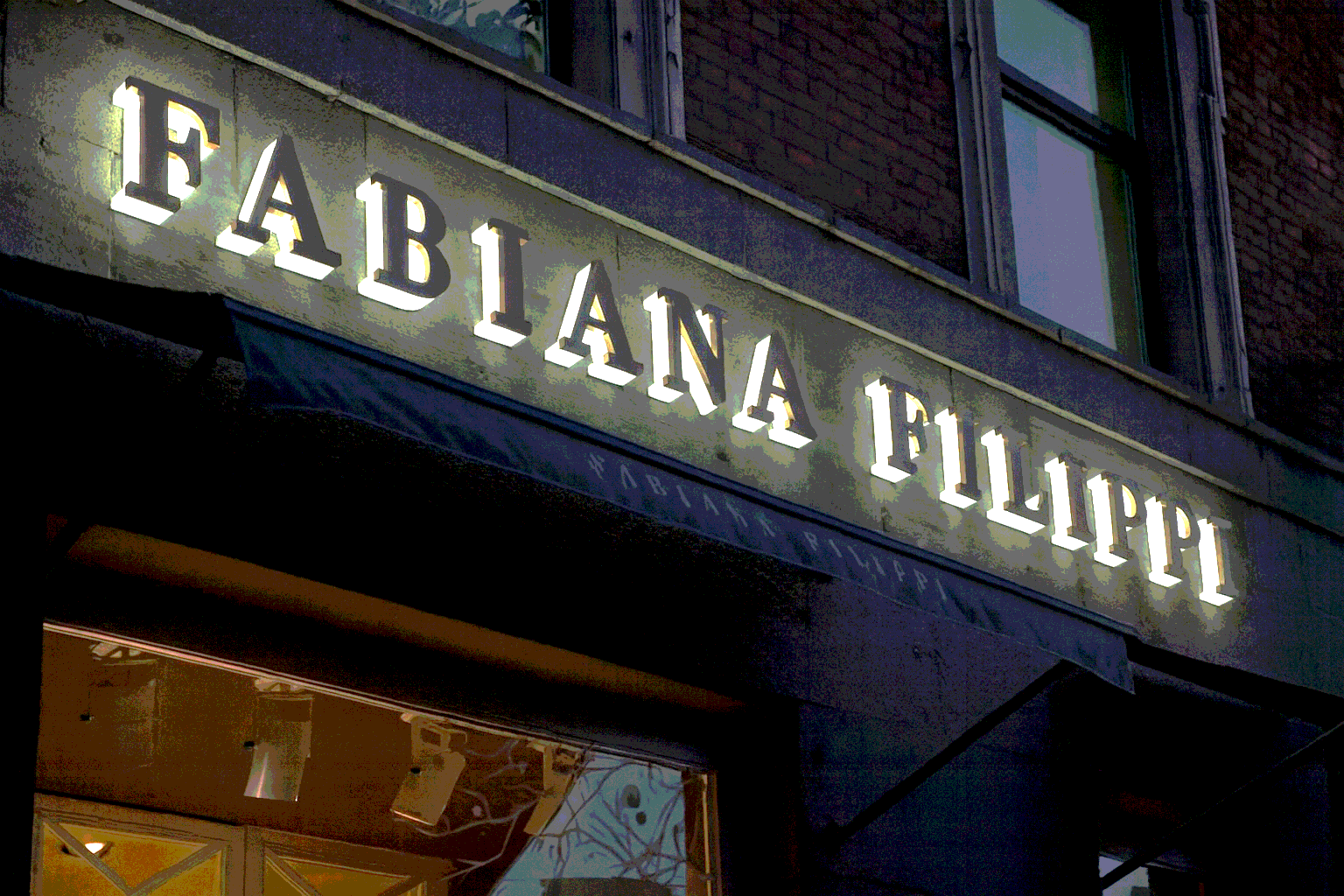 световая вывеска на фасаде бутика Fabiana Filippi в вечернее время