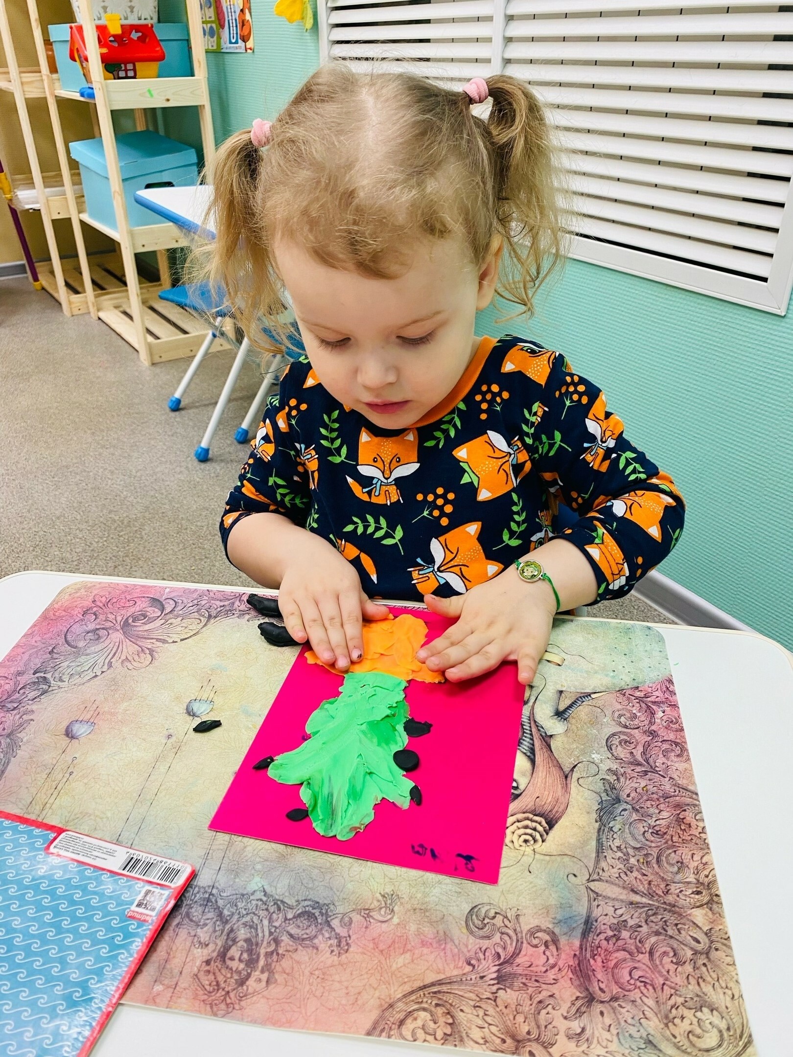 Девочка занимается лепкой в детском центре