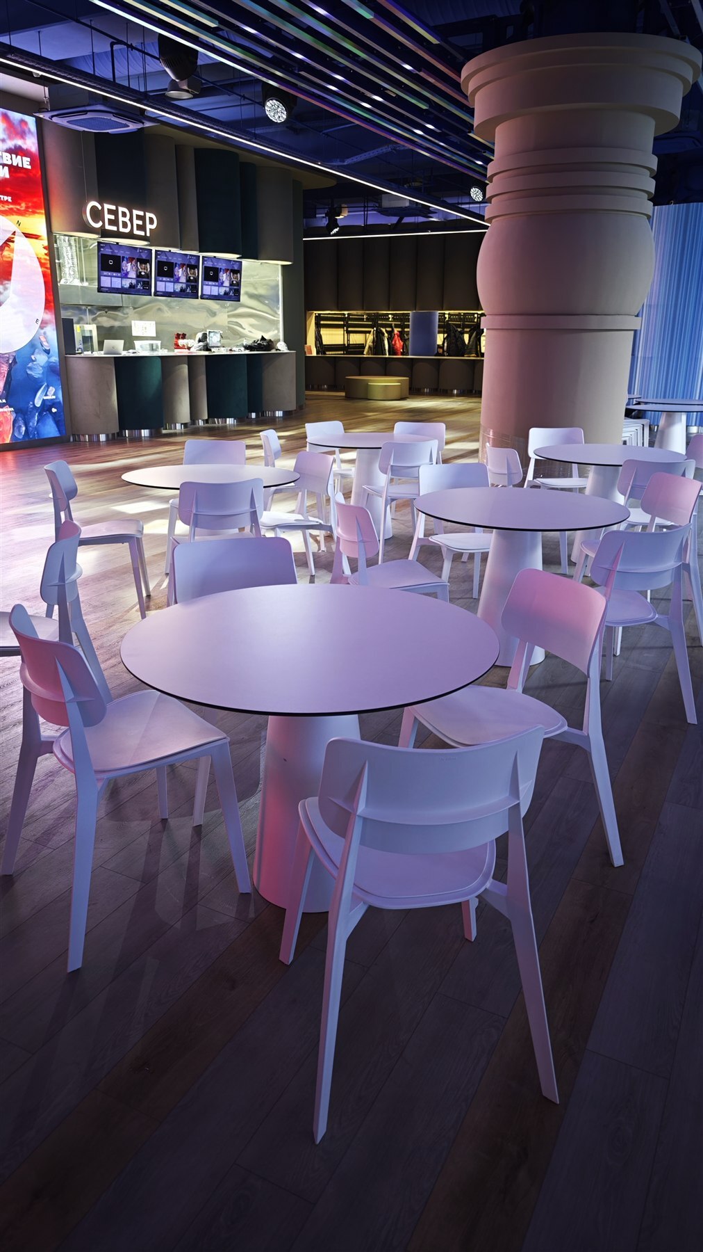 Круглые белые столы LofTable со стульями в общей зоне фудкорта