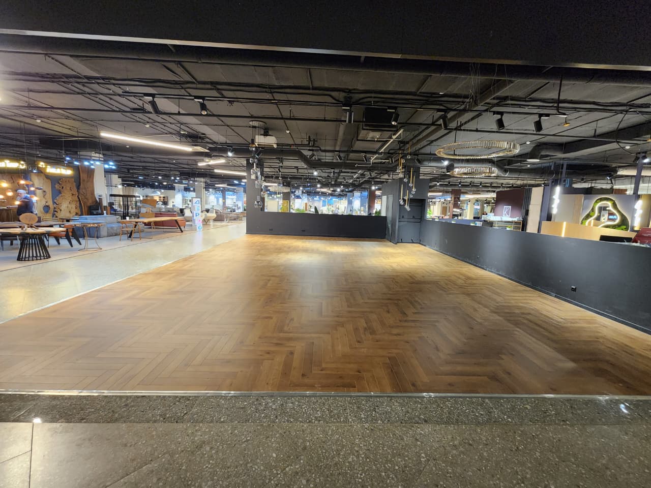 Салон «Кубатура» после укладки ламината Norland Herringbone Elegant Дуб Помона. Классическая английская ёлка визуально расширяет пространство и придаёт интерьеру завершённый, стильный вид.