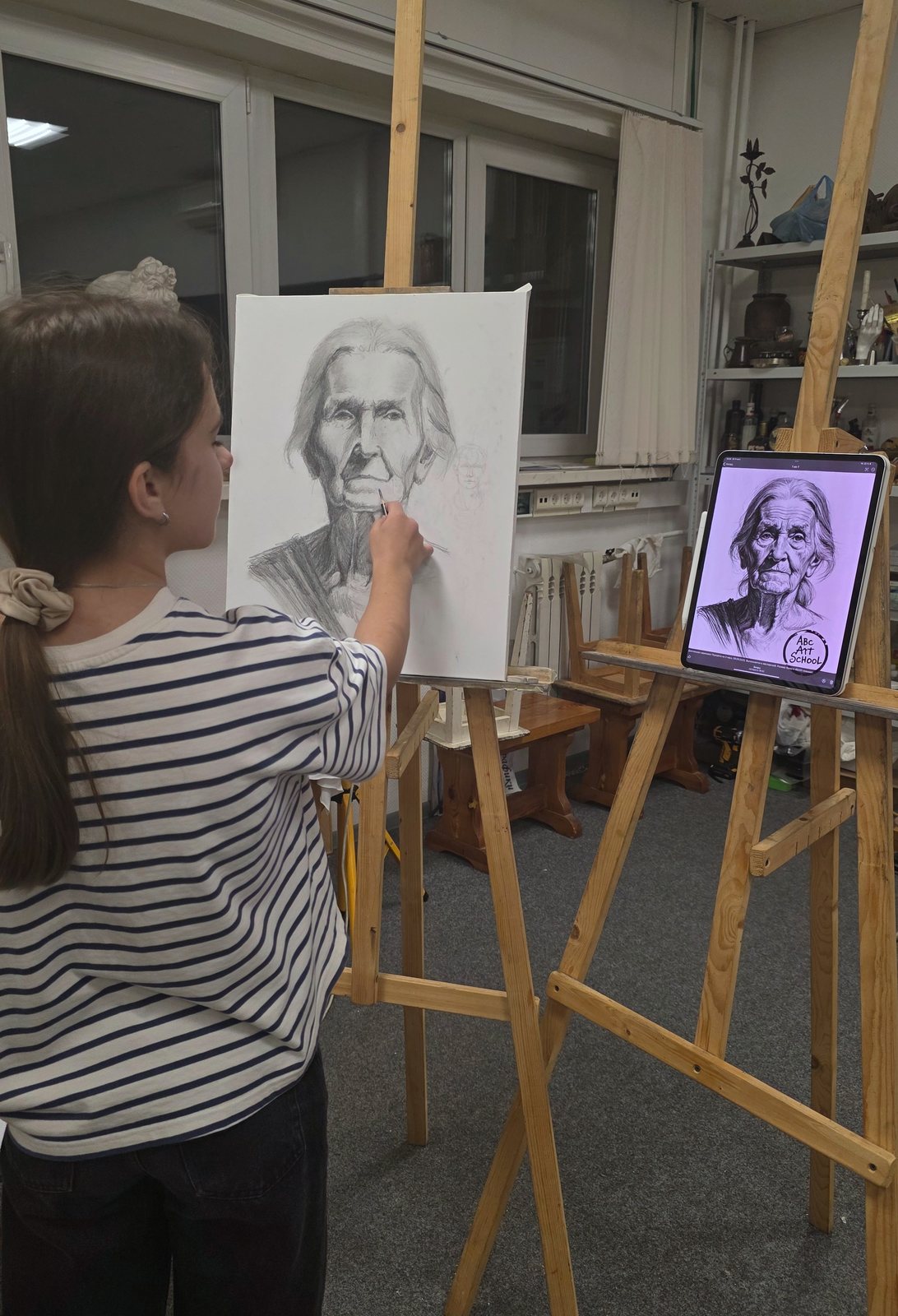 Ученица рисует карандашом портрет за мольбертом в мастерской ABC Art School в Подольске