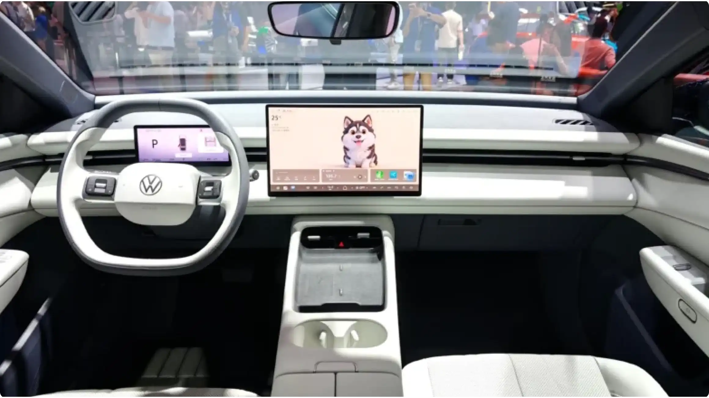 Интерьер Volkswagen ID. Era 5S: 15,6-дюймовый сенсорный экран, 8,8-дюймовая цифровая панель приборов, белый двухспицевый руль и минималистичная центральная консоль.