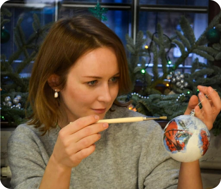 фотография девушки расписывающая елочную игрушку