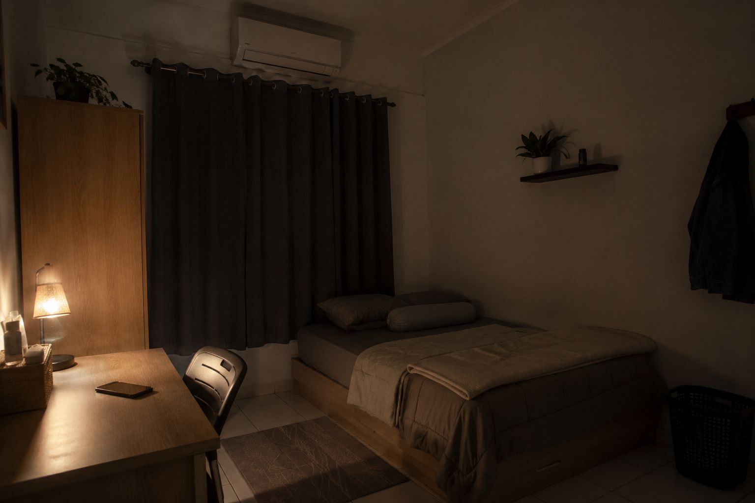 Kamar tidur redup dan rapi dengan ponsel diletakkan jauh dari tempat tidur