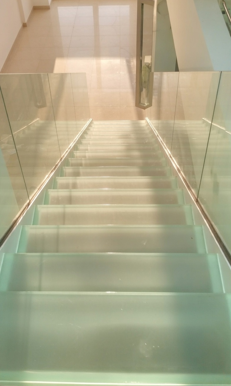 Лестница с стеклянными ступенями и ограждением.