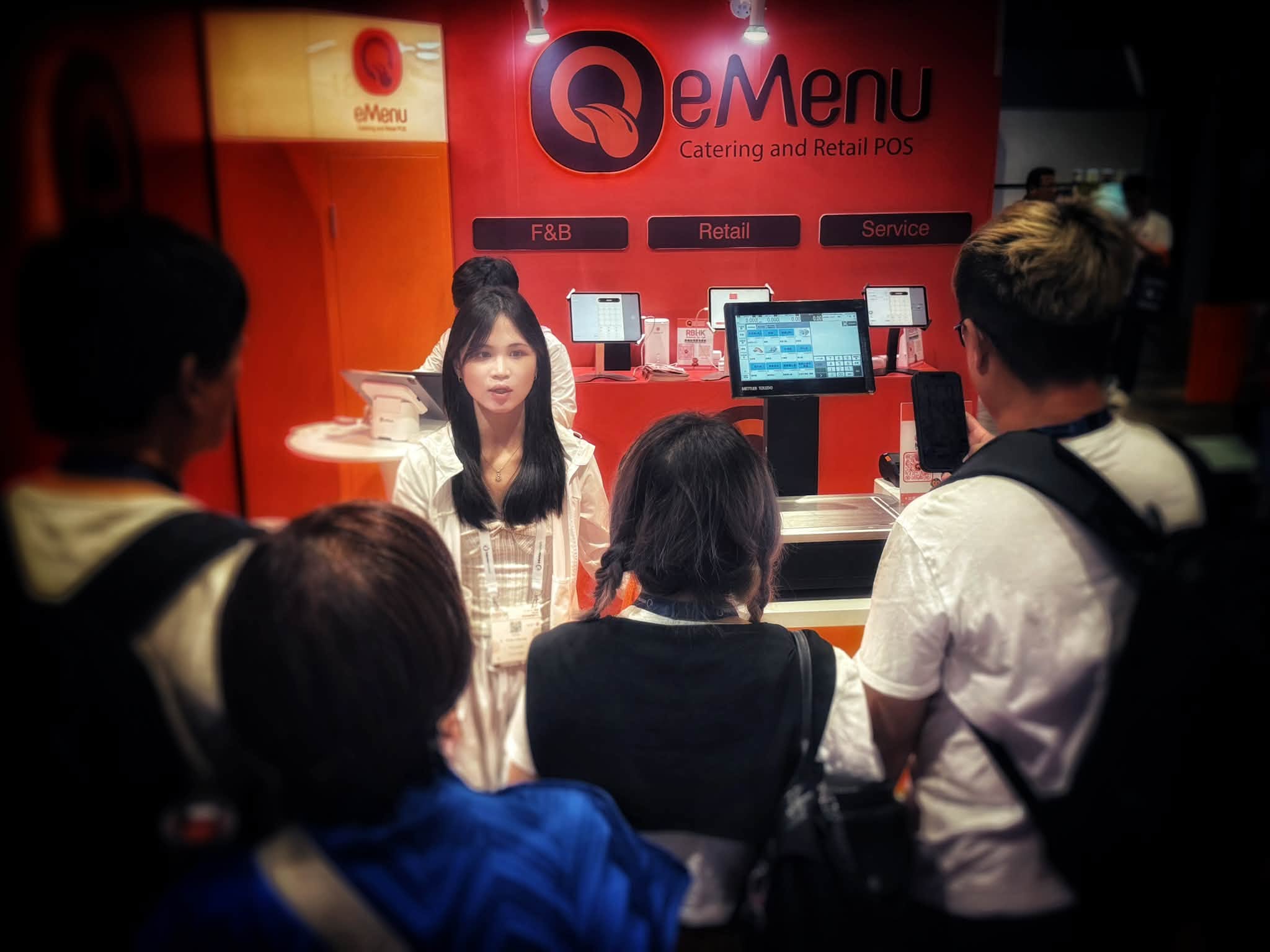 บูธ eMenu Thailand ในงานแสดงสินค้า พนักงานกำลังสาธิตเครื่อง POS สำหรับร้านอาหารและร้านค้าปลีกให้ผู้เข้าชม