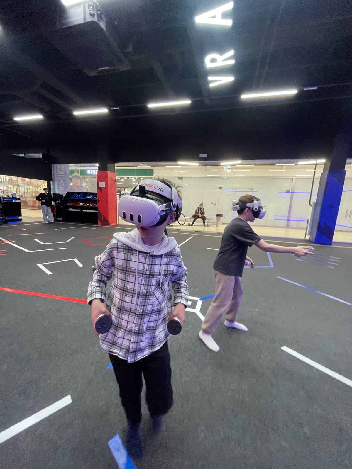 Два участника в VR-шлемах с контроллерами на арене Portal VR в Сыктывкаре