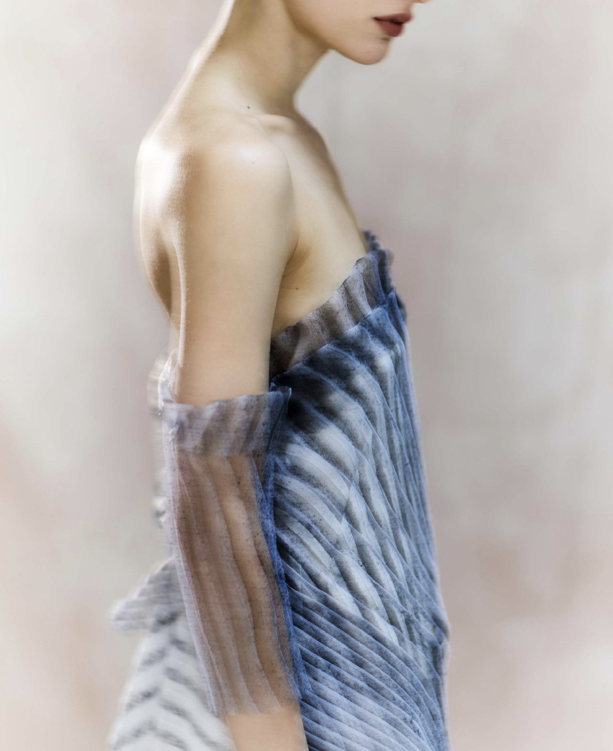 Model in a powder-blue pleated dress, shoulder detail and fabric texture - SUPERSTUDIO collections for retailers