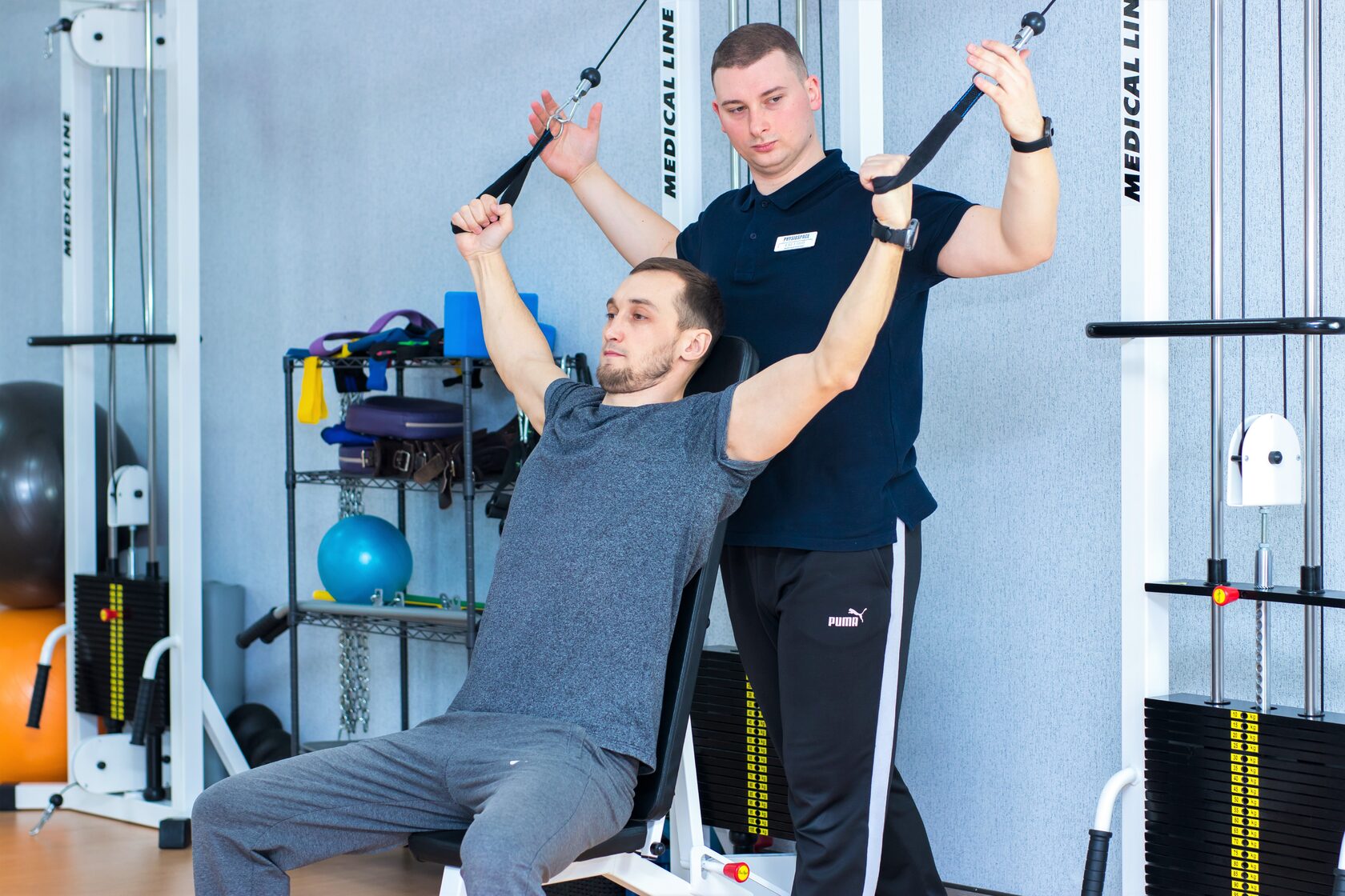 Реабилитолог и пациент в зале ЛФК