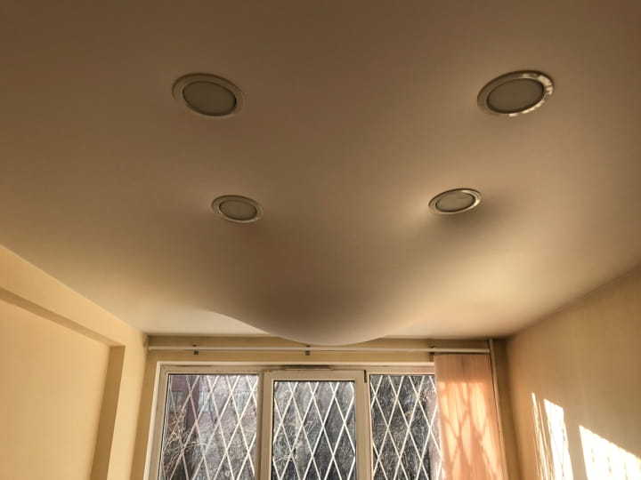 Процесс слива воды с натяжного потолка в Москве