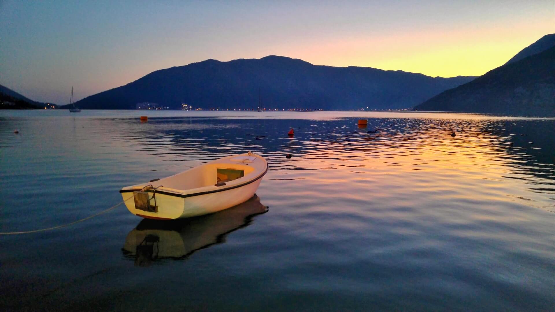 Image of a small fishing boat on Boka Bay in Montenegro at sunset