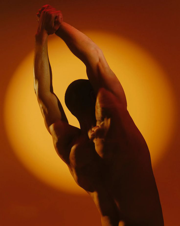 Stretching figure against a warm glow