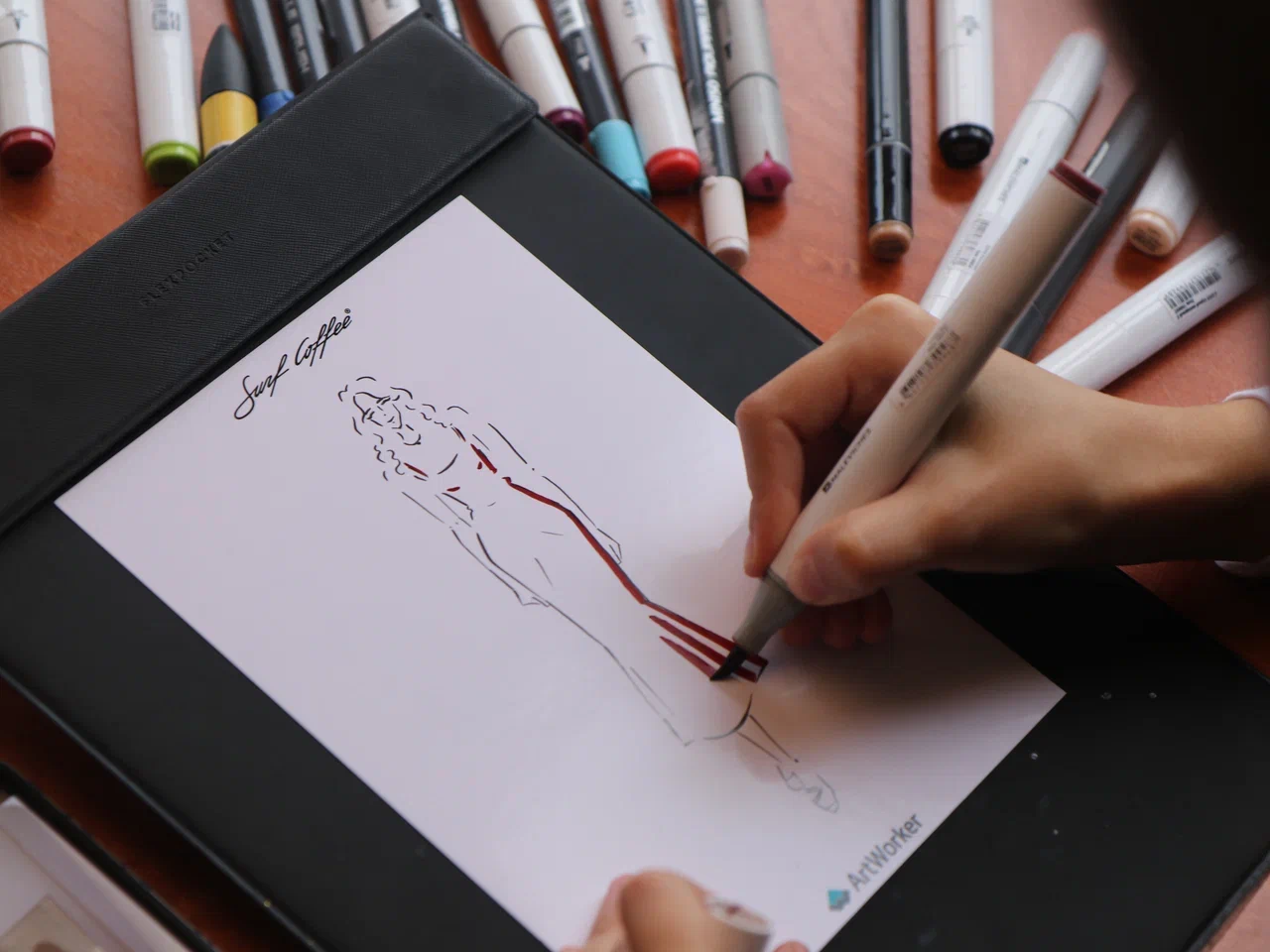 Художник ArtWorker рисует фэшн-скетч гостьи маркерами на плотной бумаге формата А5