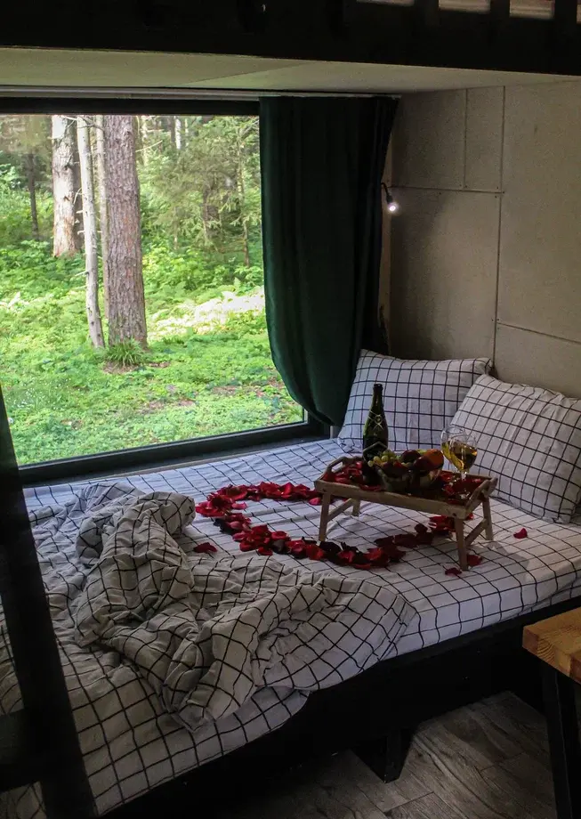 Романтическое оформление домика в глэмпинге Тишина: кровать с лепестками роз, шампанским и фруктами с панорамным видом на лес — услуга Romantic Home для двоих недалеко от Перми