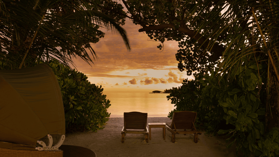 Закатный вид с пляжа виллы Beachfront Sunset Villa: два кресла у воды