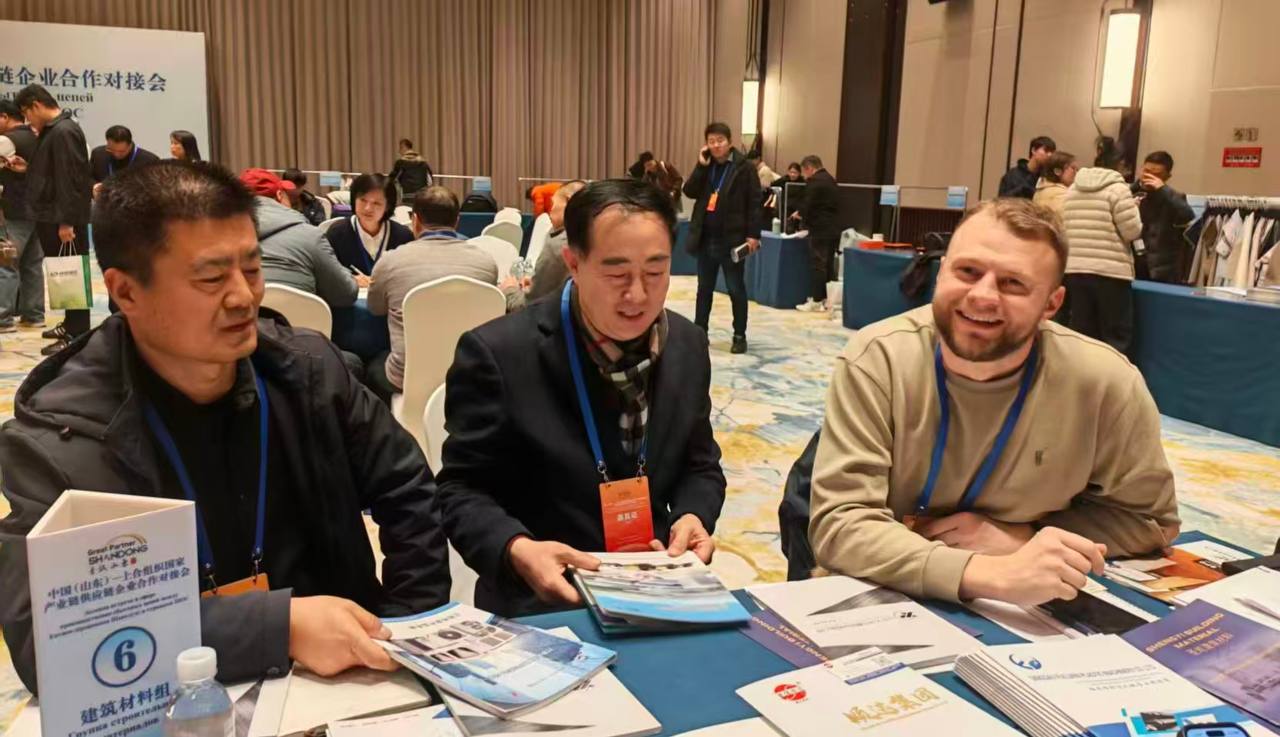 Группа молодых людей в деловых костюмах на выставке в Китае