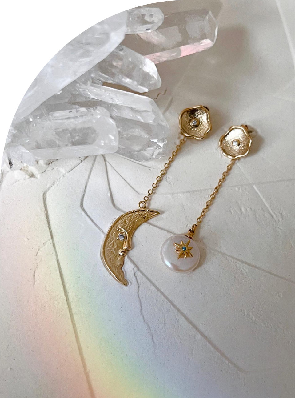 Асимметричные серёжки, украшенные фианитами, дополнены подвесками в виде полумесяца и звезды, в натуральном жемчуге.