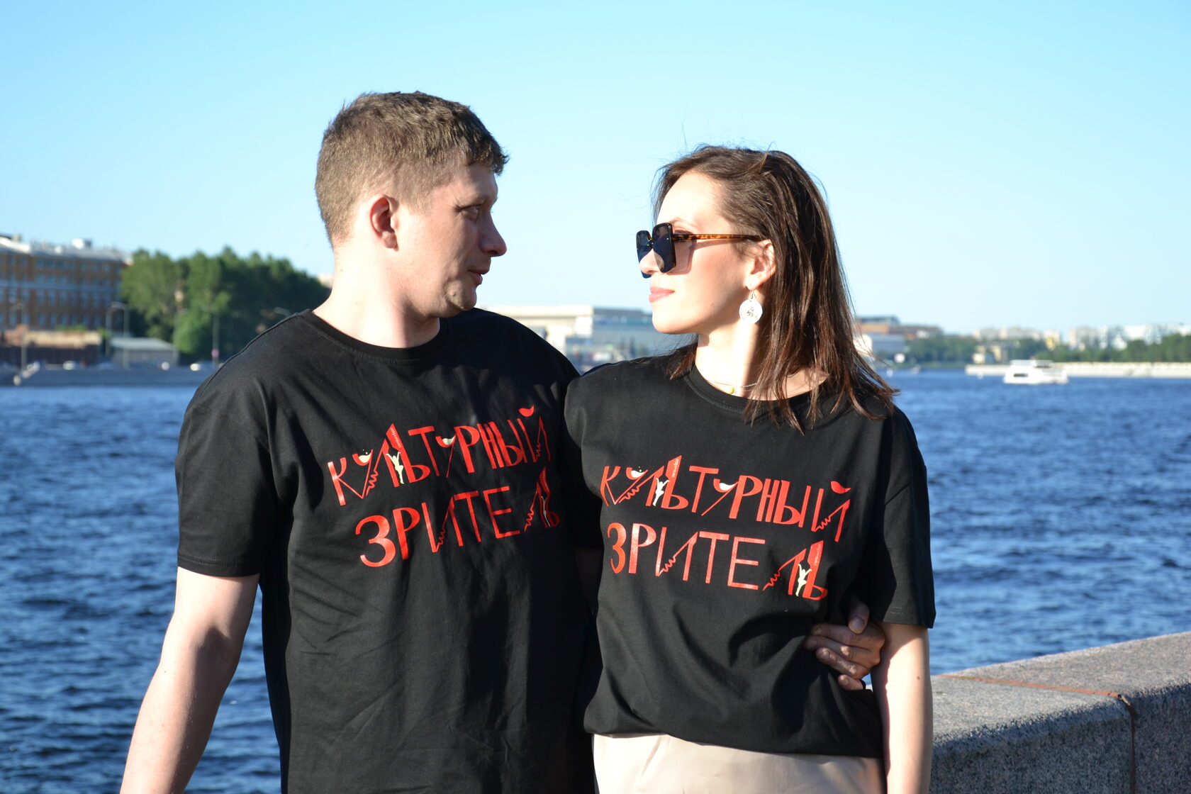 Пара в футболках «Культурный зритель» на фоне Невы