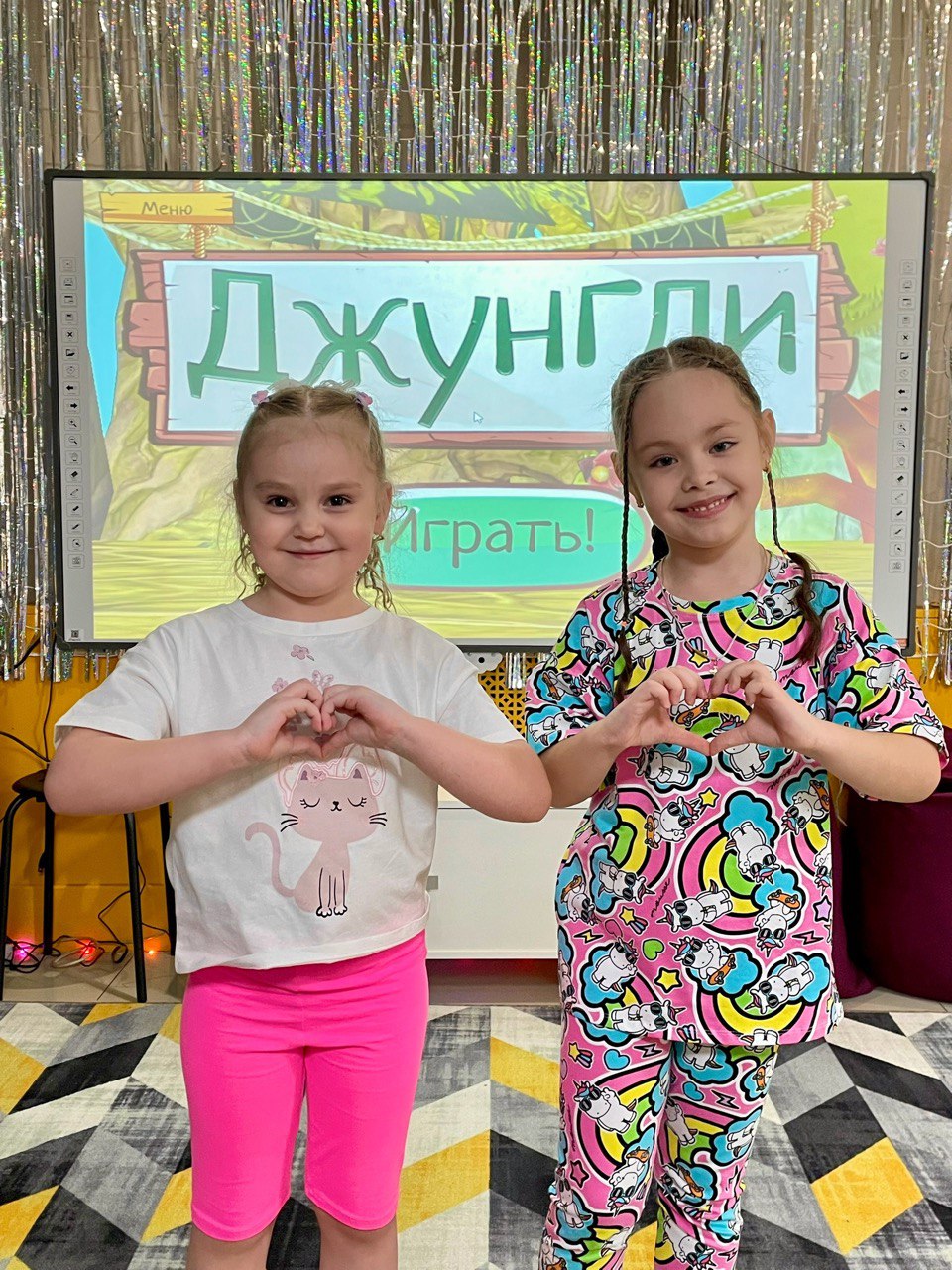 Дети играют в интерактивные игры на большом экране в студии «Интерактивия»