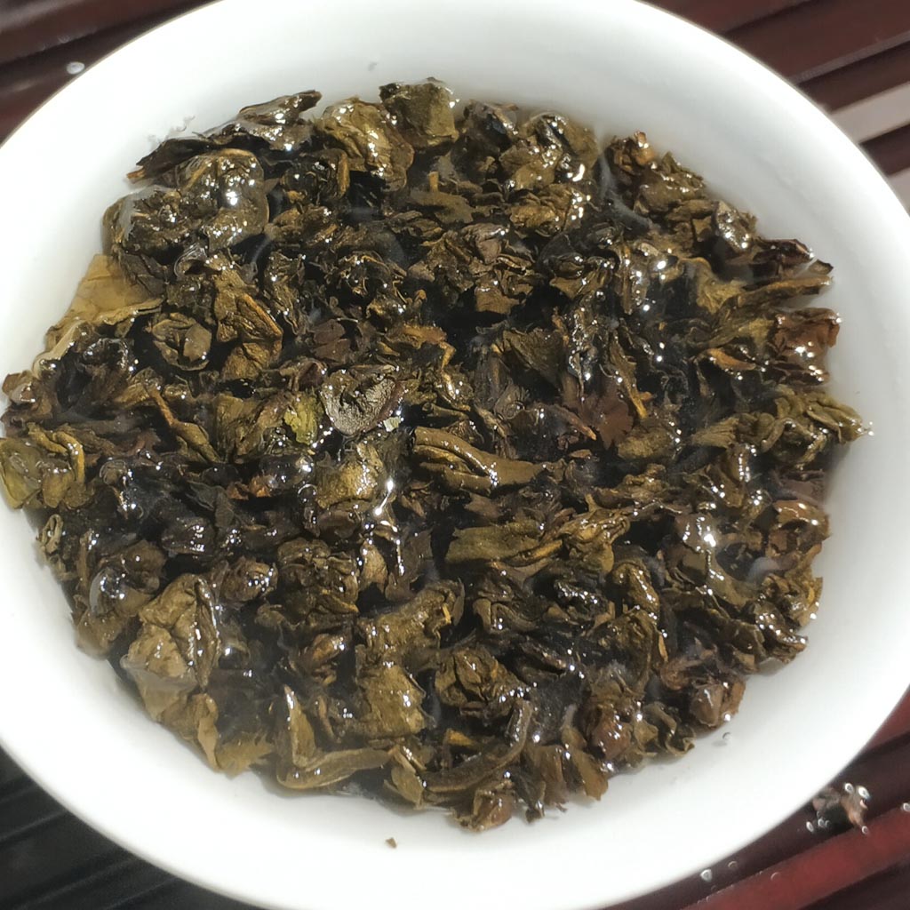 Deep amber aged tea liquor in a white porcelain cup