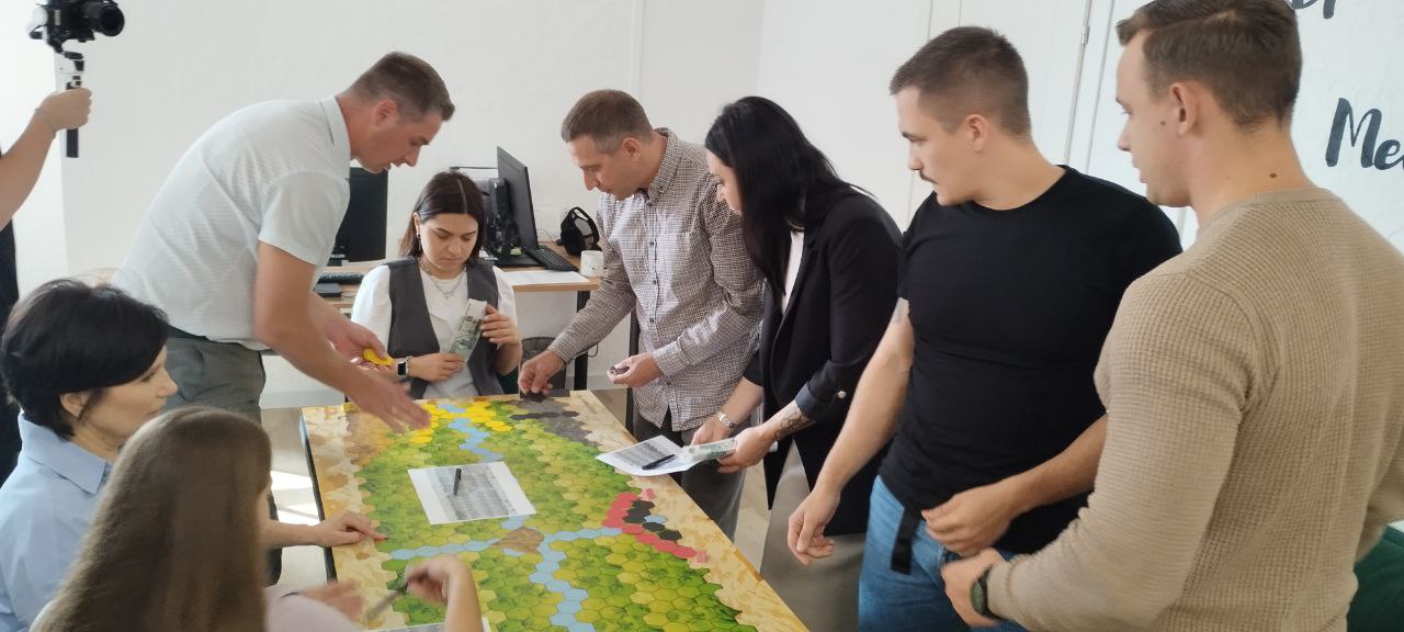 Участники реального мероприятия обсуждают решения за игровым столом