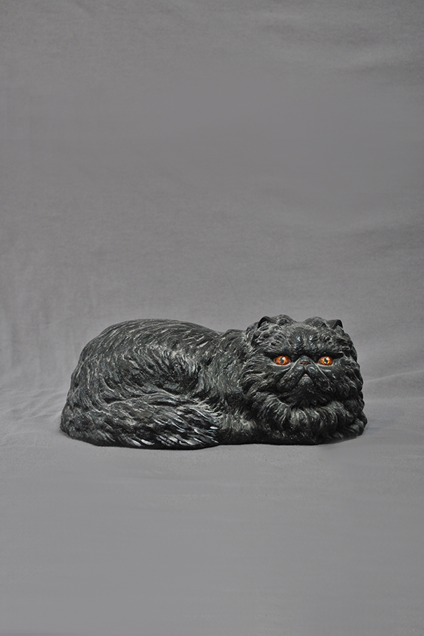 скульптура лежащего черного кота
