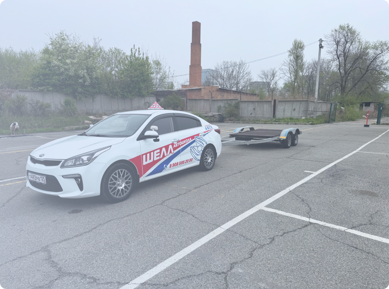 Черно-бронзовый мотоцикл стоит на стоянке у серого бетонного здания, вид сбоку