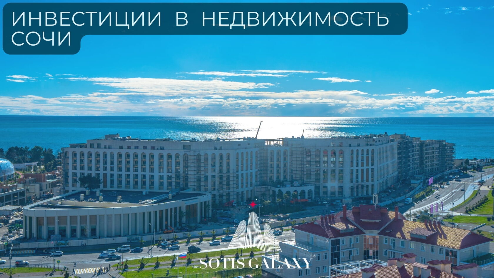 Инвестиции в недвижимость Сочи - вид на крупный жилой комплекс у моря на фоне солнечного неба.