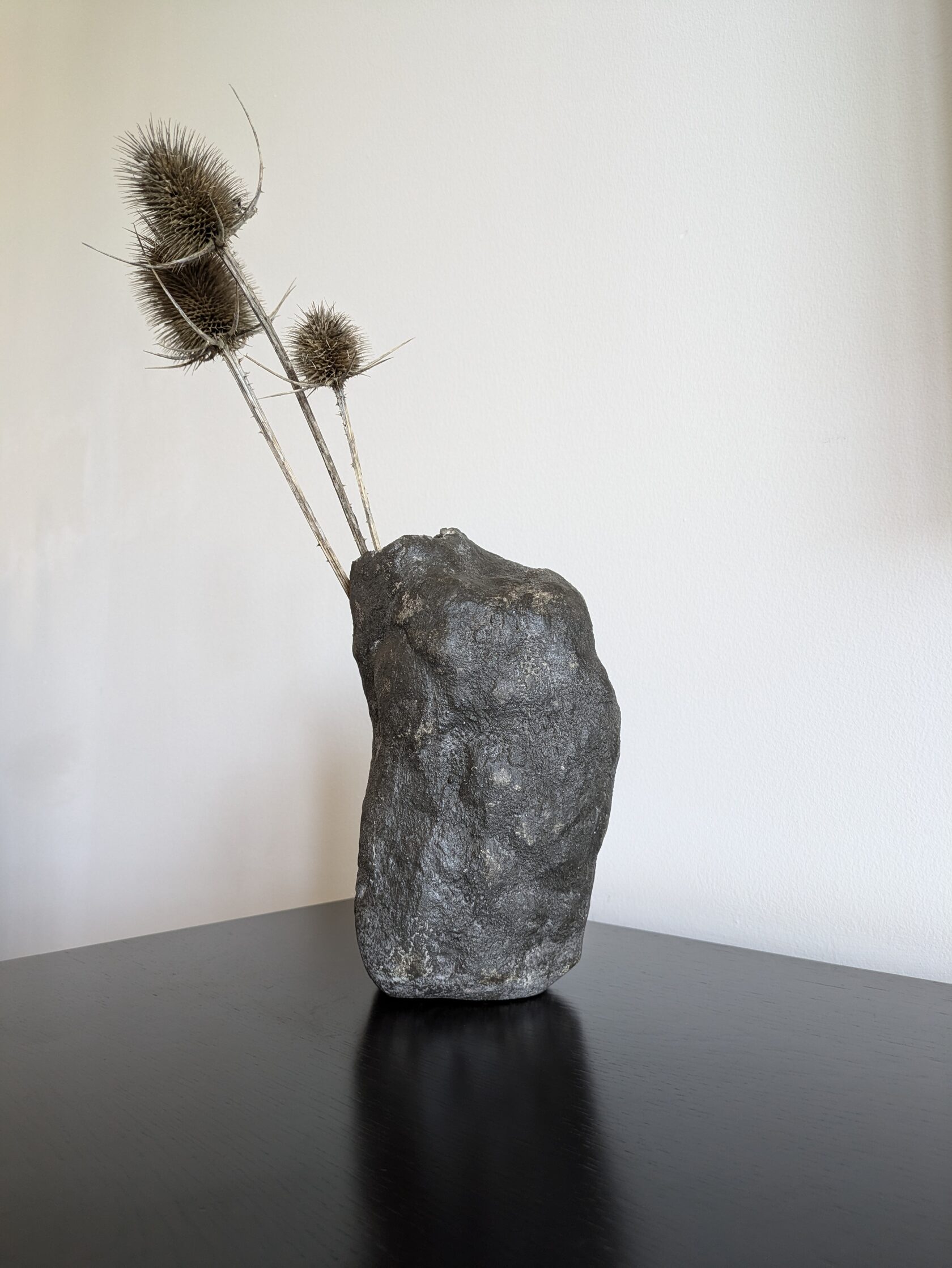 Entryway console table decorated with sculptural and handmade  vases.