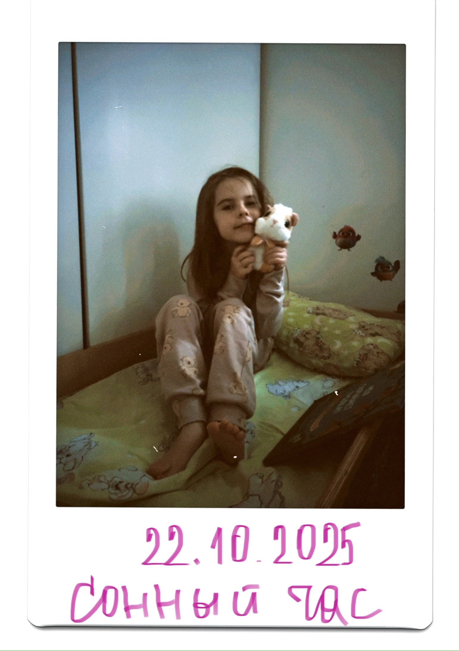 Ребёнок сидит на кровати с мягкой игрушкой во время тихого часа в детском саду