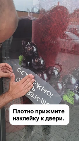 Сотрудник плотно прижимает фразу к стеклу