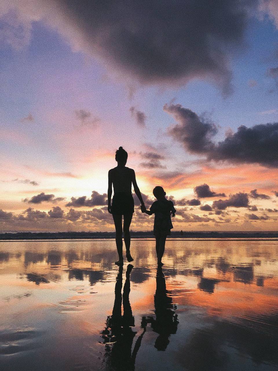 мама с дочкой на море смотрят на закат