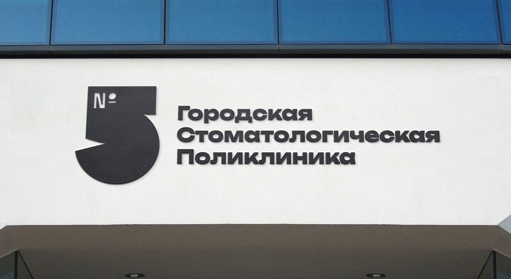 Вывеска «Городская стоматологическая поликлиника» с пятёркой на фасаде