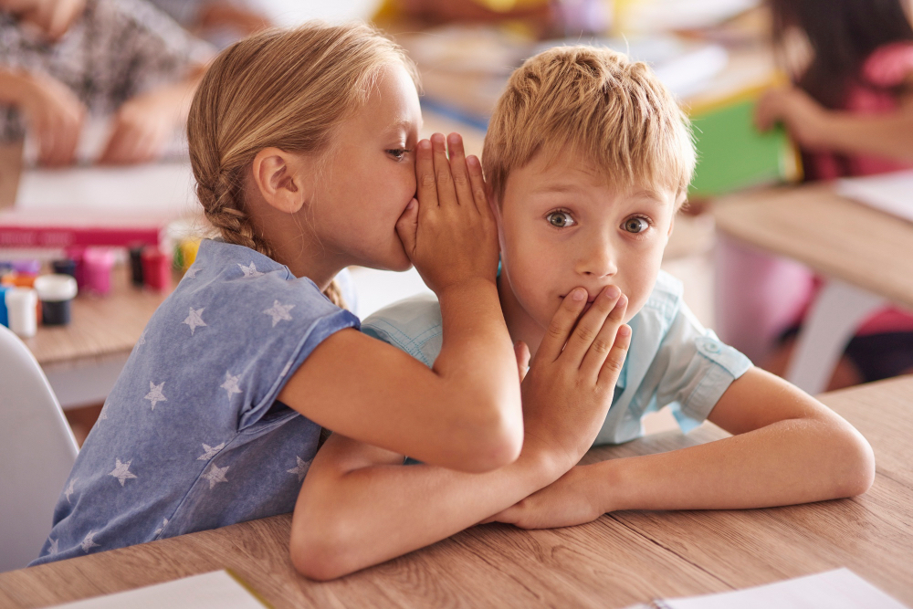 A girl is telling her school friend a big secret.