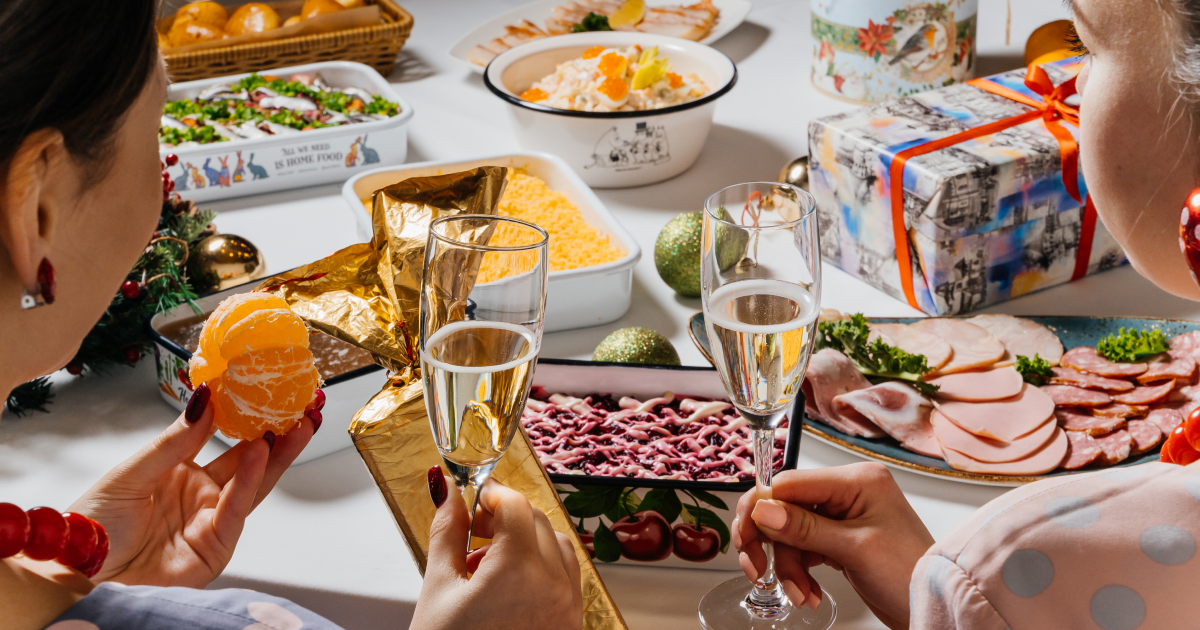 Люди отмечают День экономиста за столом с тортом, украшенным золотыми монетами.