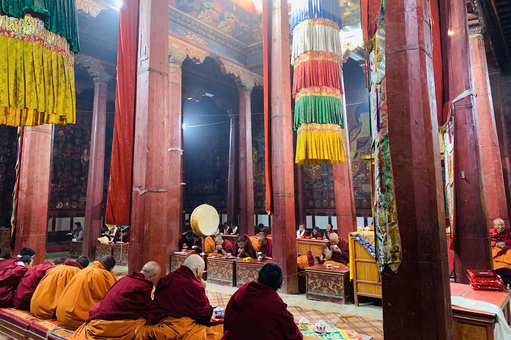 Интерьер Тубчен Гомпы в Ло-Мантанге: буддийские монахи во время коллективной практики в главном зале собраний, Верхний Мустанг, Непал