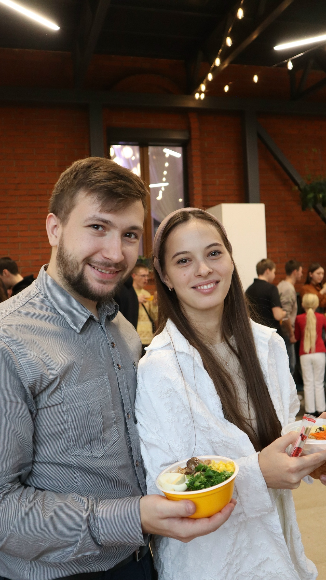 Парень и девушка улыбаются с тарелками