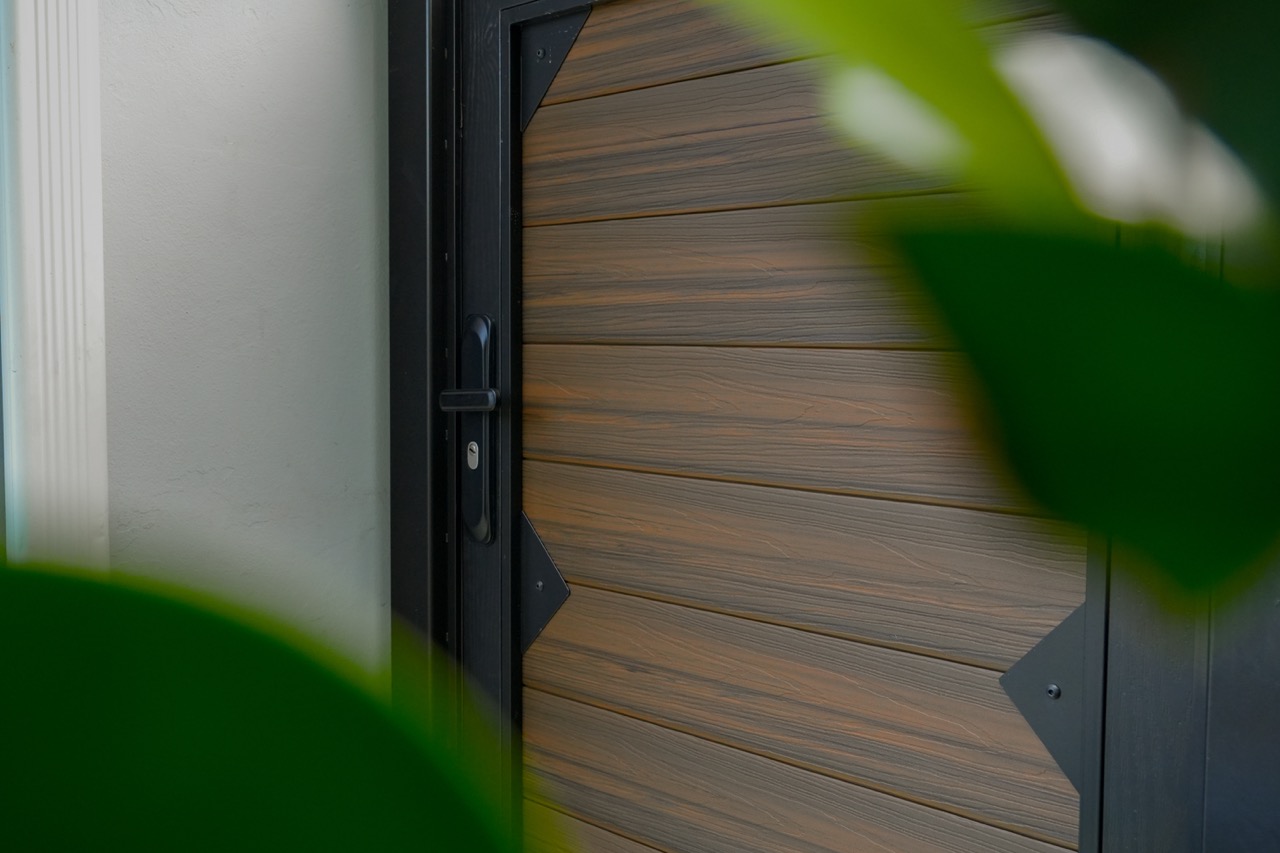 Close-up of wood-look WPC gate finish with greenery