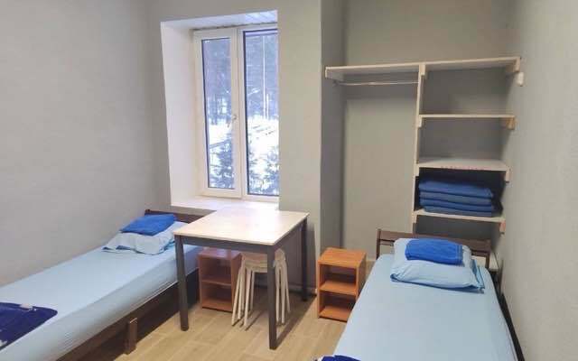Комната в корпусе: две кровати, стол и полки