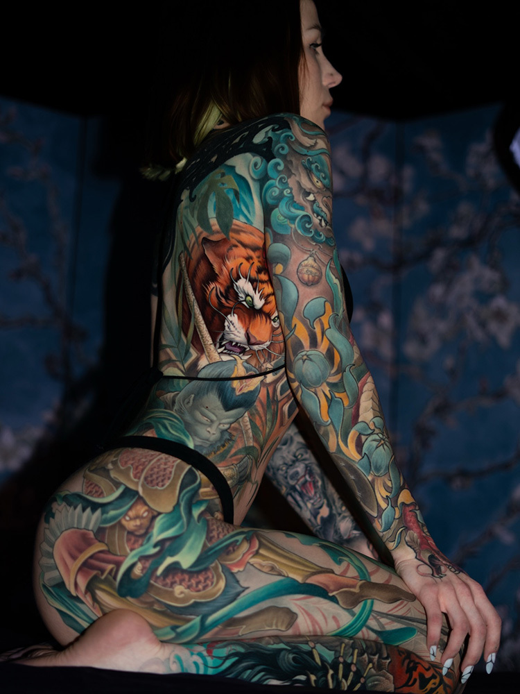 The Complete Tattoo Aftercare Guide From Day One to Full Healing, Woman showcasing a full back and thigh Japanese style tattoo bodysuit with a tiger and mythological figures, 217