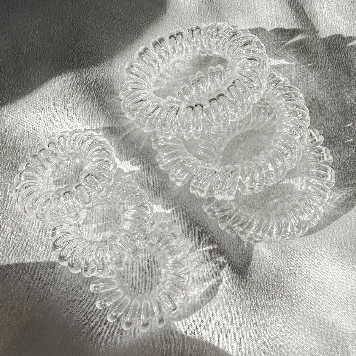 Прозрачные резинки Invisibobble на сером фоне