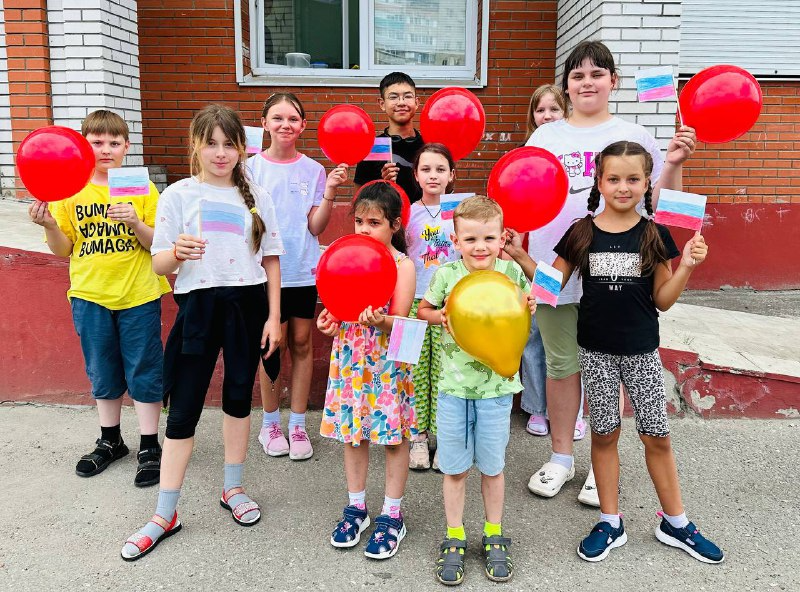 дети с вожатым детского летнего лагеря стоят около кинотеатра Алмаз