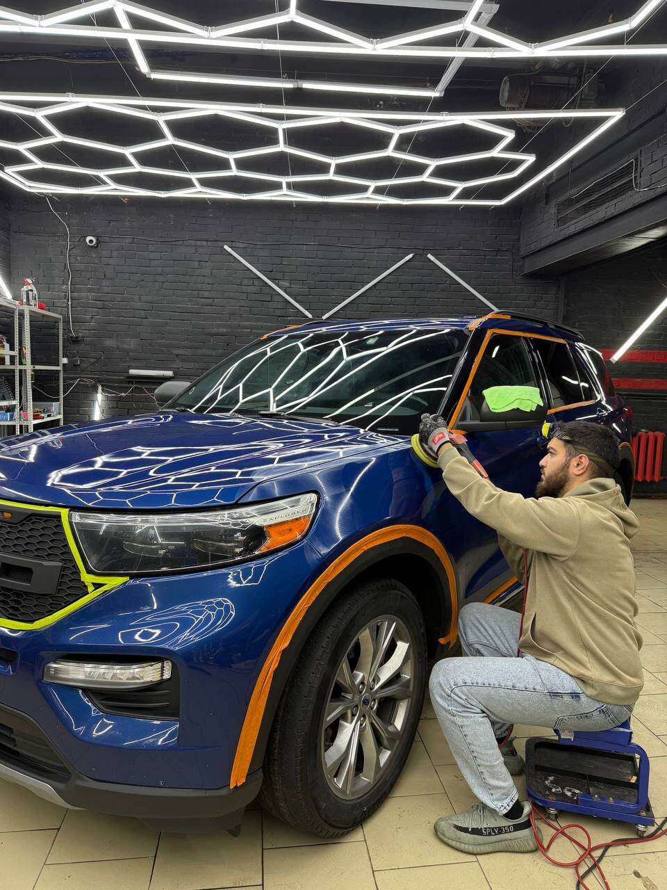 Мастер полирует переднее крыло Ford Explorer