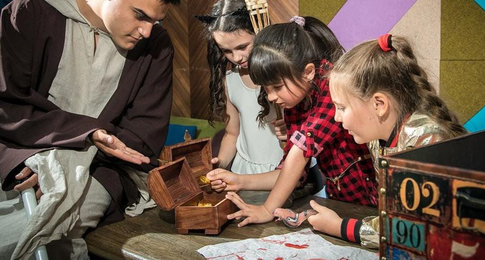 Дети проходят квест с сундуком и заданиями как вариант выпускного для класса