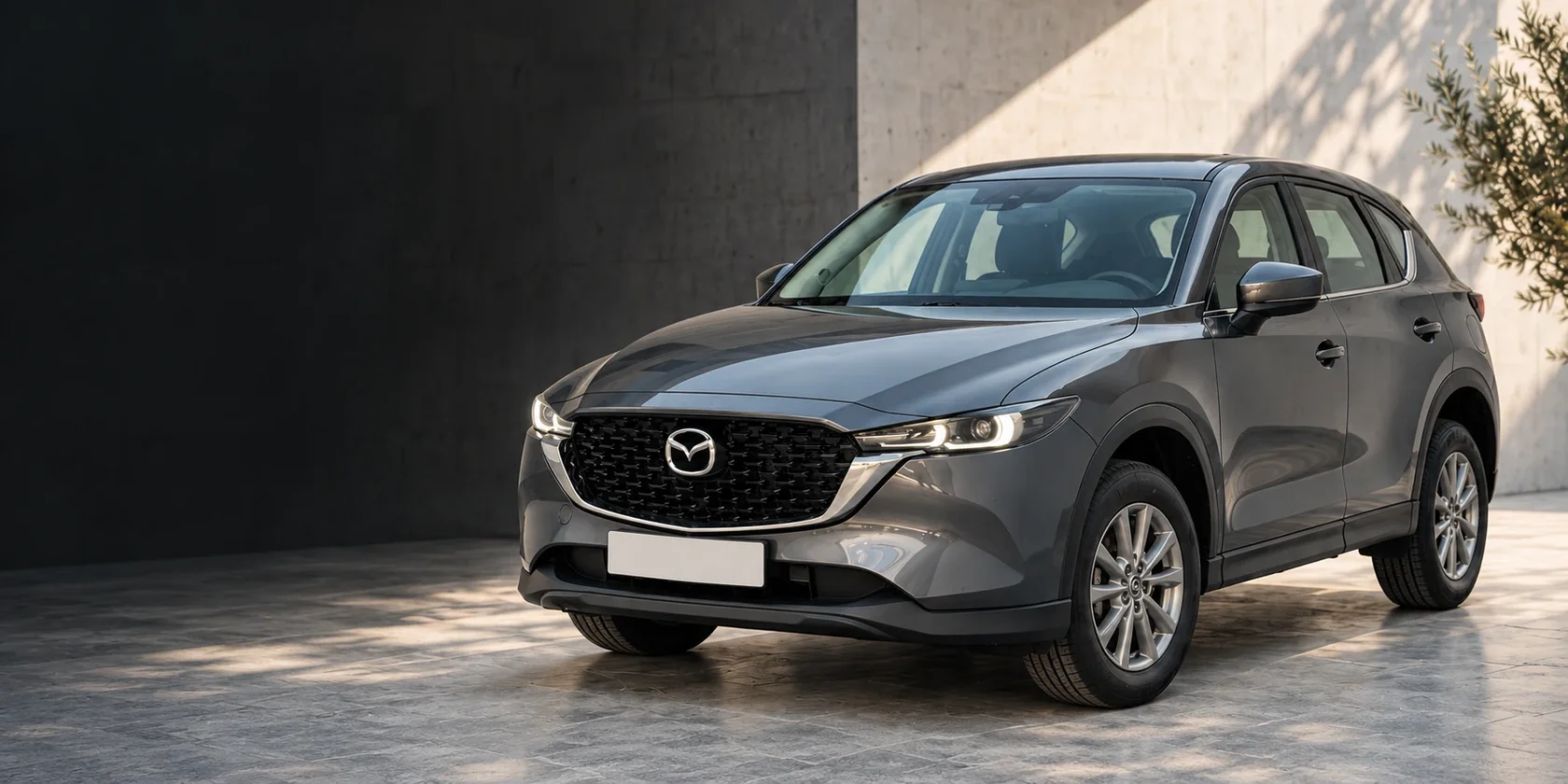 Серая Mazda CX-5 у светлой каменной стены