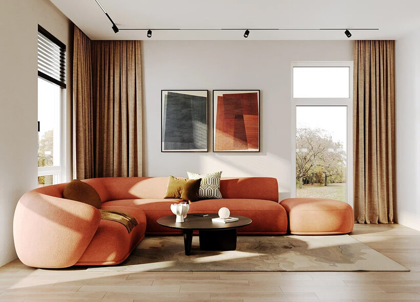 Дизайн интерьера в тёплых тонах. Бежевые стены, светлое пространство, бежевые шторы, оранжевый диван со скруглёнными формами, квадратный бежевый ковёр, бежевые шторы, круглый журнальный столик из тёмного дерева, картины на стене