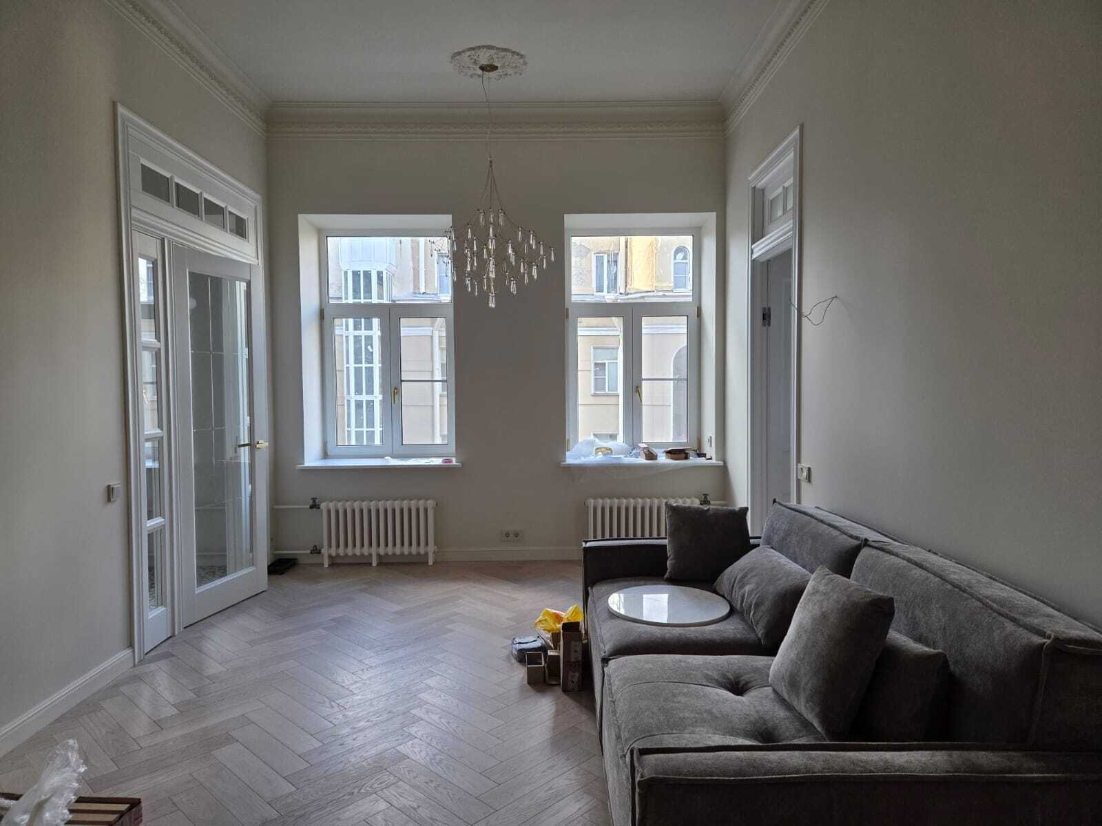 Перспектива от входа к зоне отдыха: частый шаг планки 500×110 подчёркивает глубину комнаты, тёплый оттенок Blond и V-фаска создают графику «тихой роскоши». Инженерная доска 14/3, сортировка Селект. Заказ в Parket Brothers; приходите в шоурум Санкт-Петербурга.