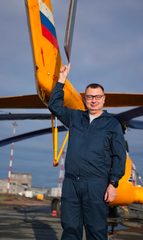 Балдин Вадим Борисович, директор АО "Авиакомпания Геликс" в рабочей униформе на фоне вертолёта 