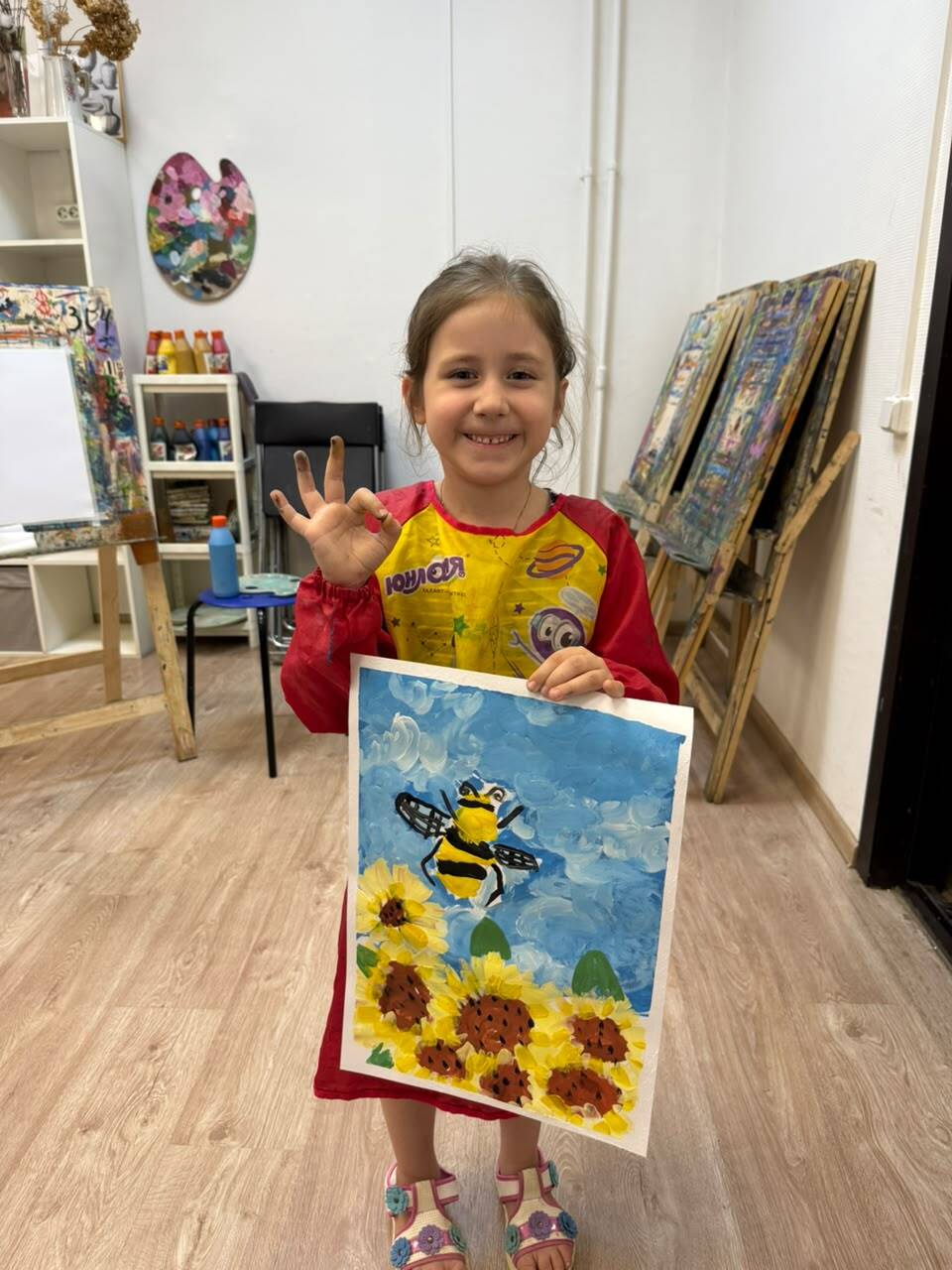 Ученица 4–5 лет с рисунком пчелы и подсолнухов