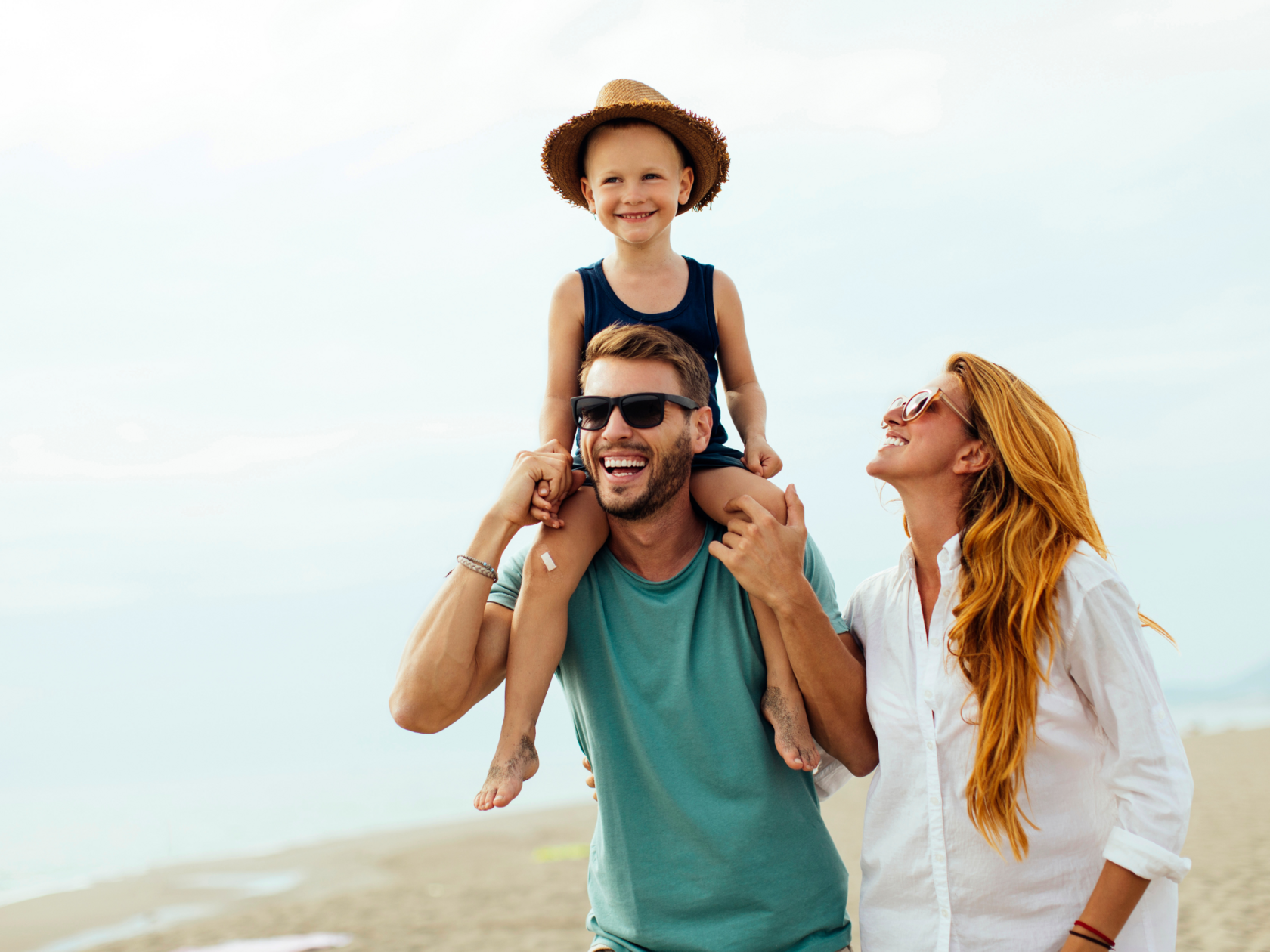 Счастливая семья на пляже во время отпуска — мама, папа и ребёнок улыбаются и наслаждаются отдыхом. Подготовка к отпуску у стоматолога.